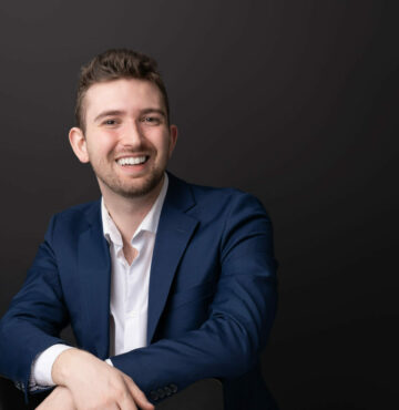 Smilende Oskar Fagerlund som sitter på en stol